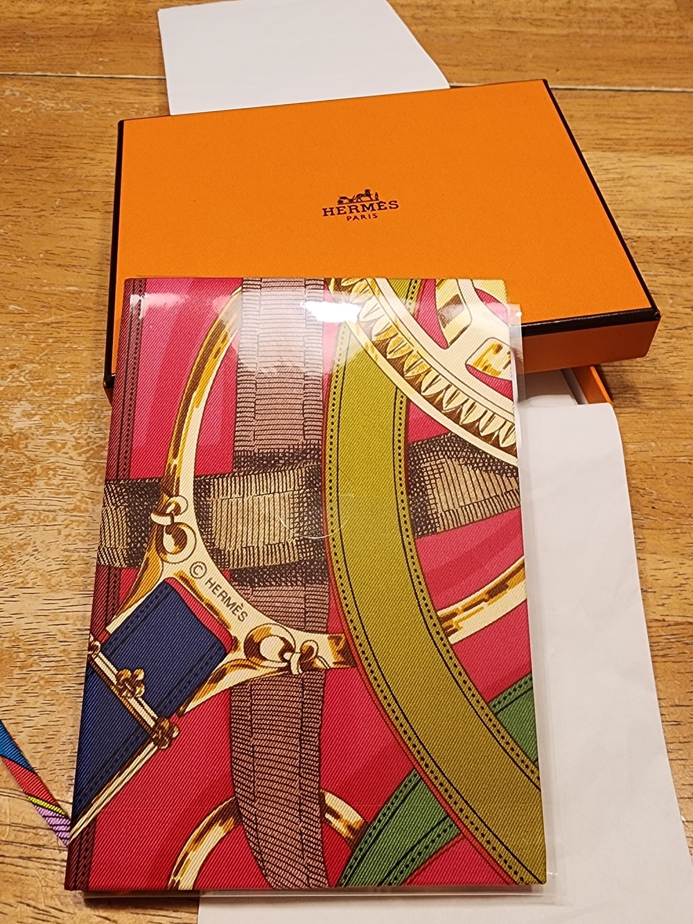 Hermès Cavalcadour Silk Notebook featuring an intricate equestrian-themed print.
